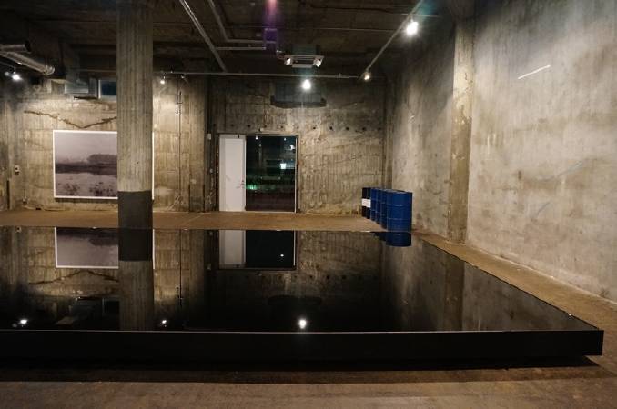 由港灣倉庫改建而成的BankART Studio NYK，空間性格極適合當代藝術展出。前方為日本藝術家原口典之（Noriyuki Haraguchi）的油池作品。