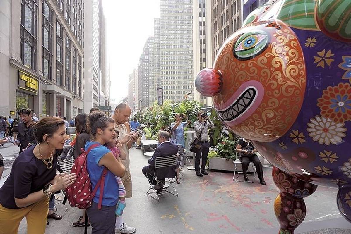 在紐約百老匯街頭，遊客十分喜愛與笑臉迎人的《三羊開泰》之作。（攝影／林亞偉）