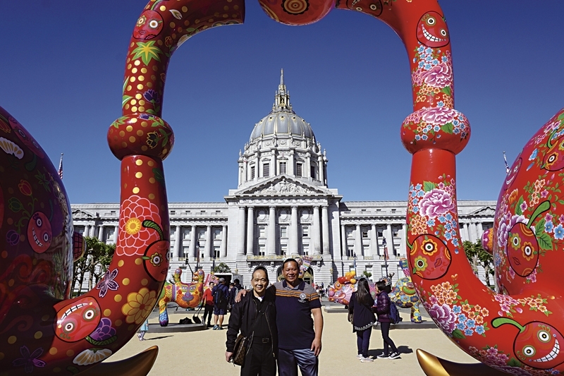 印象畫廊負責人歐賢政,與洪易在《分享象》作品合影。《分享象》,已經行遍日本、台灣到美國等地。