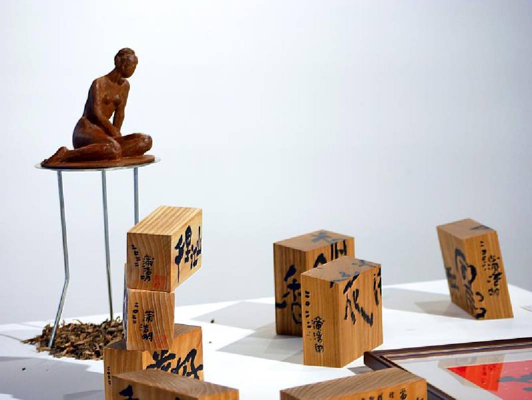 《蒲浩明跨域裝置展》展場中唯一的具象雕塑作品〈女人像〉耐候鋼鑄造，時間刻痕體現侘寂之美學觀，與原木的原始生命力輝映。