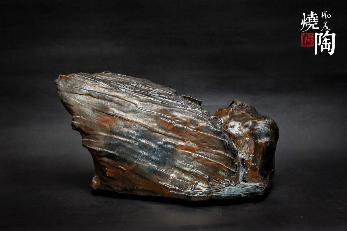 將自然岩石的肌理以陶土雕塑成形，透過柴燒獨特的隨機自然燒成色澤，呈現在雕塑與茶器之上，傳達作者對山水元素的詮釋