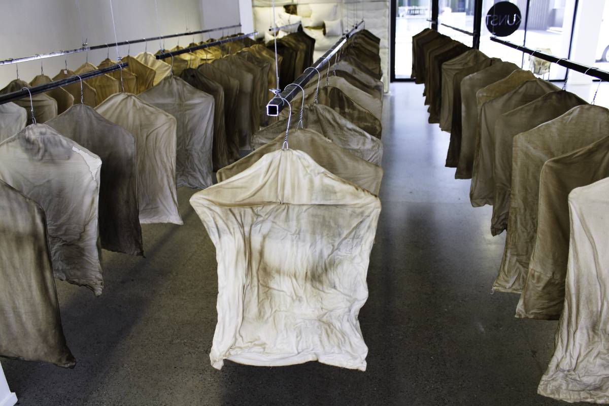 Garment bags, 2016, Dimension variable, 80 small torso-like Textile objects stuffed, stained by coffee 2