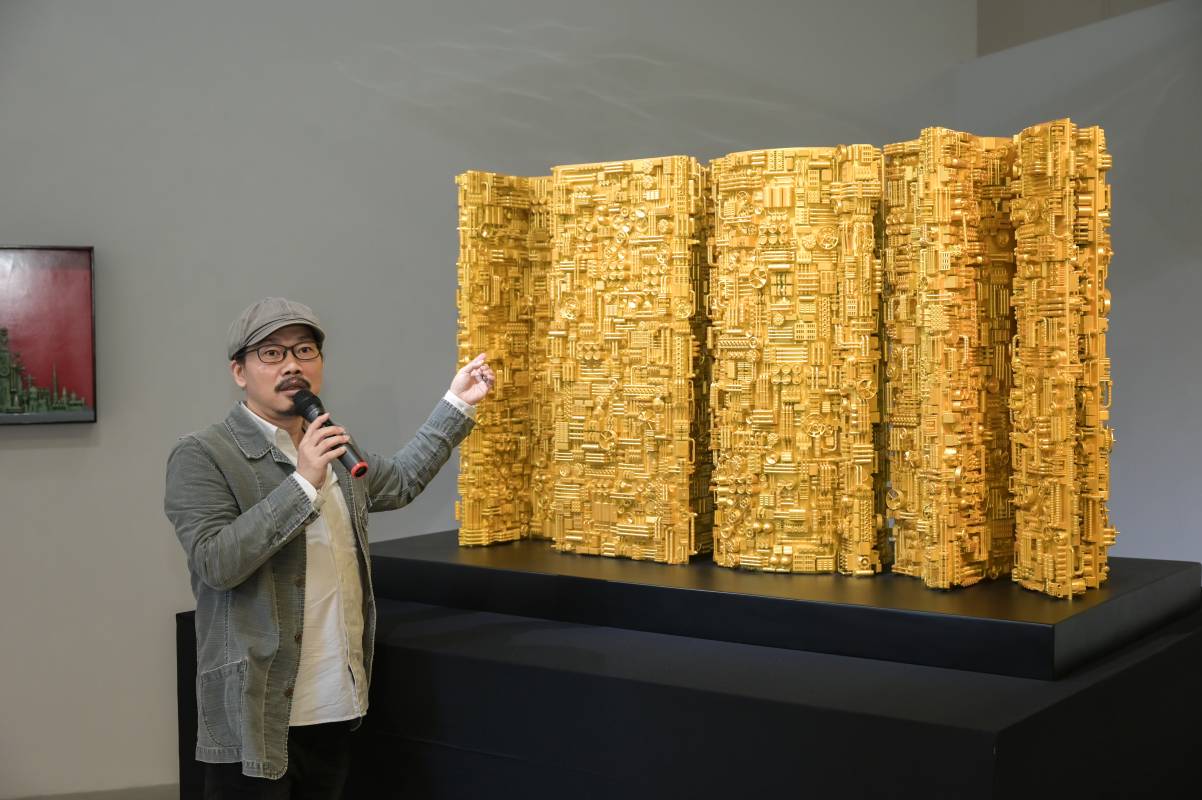 方文山在索卡藝術舉辦的個展開幕酒會上,為訪客解說龐克蒸氣系列代表作[之外有千里]的奧妙寓意(大將文創提供)
